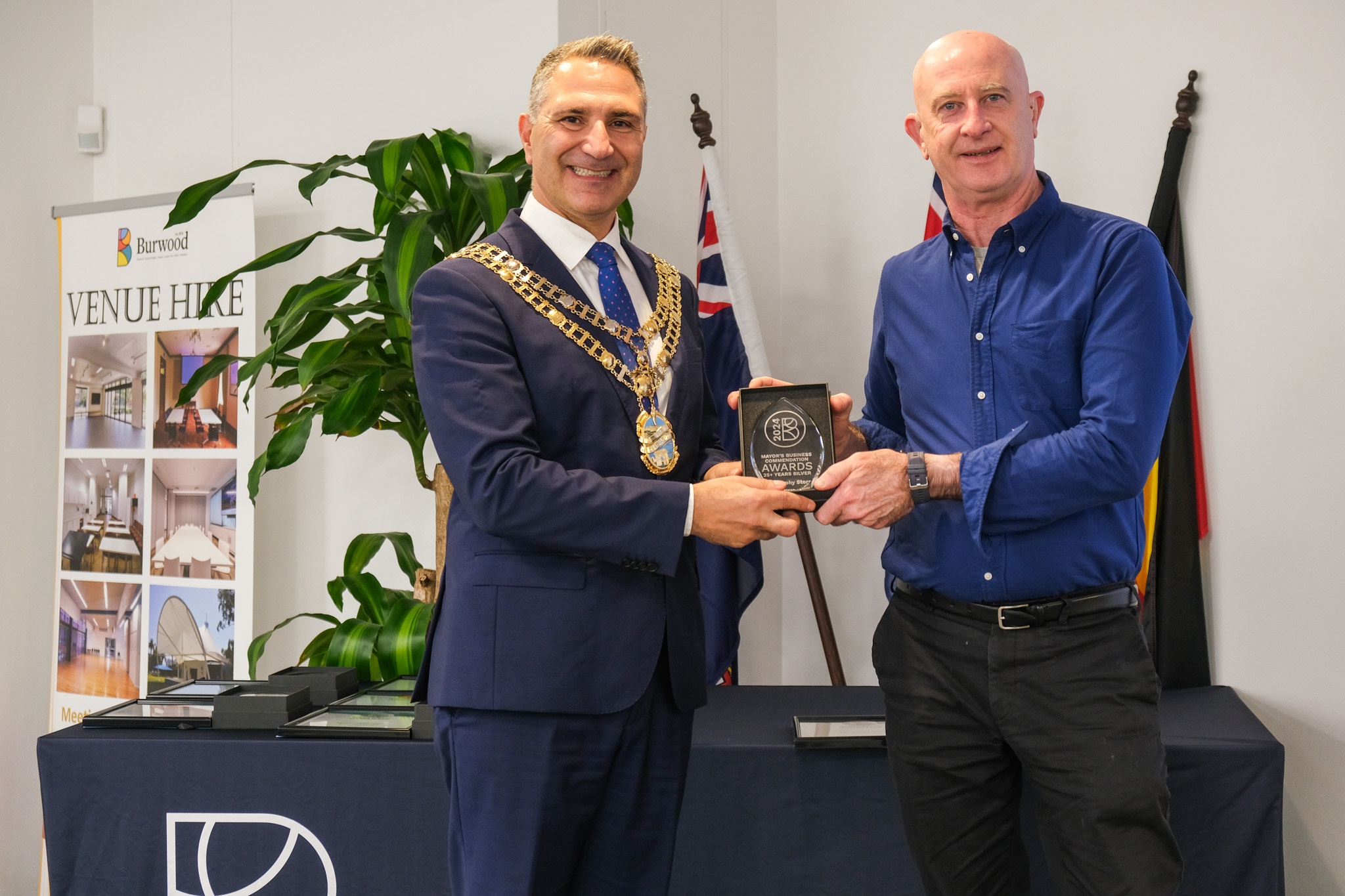 image of owner accepting award from the mayor