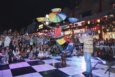 street performer balancing umbrella and bowls